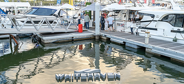 boats in marina with whitehaven logo in water