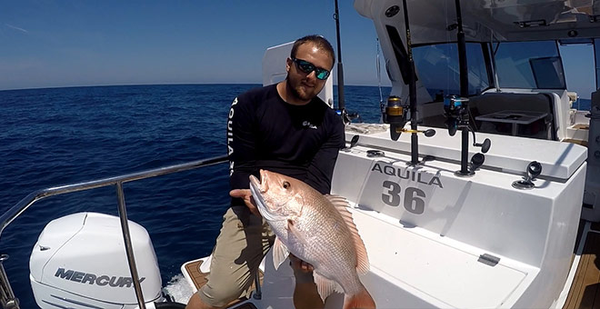 Man holding fish on the Aquila 36 fishing and diving version