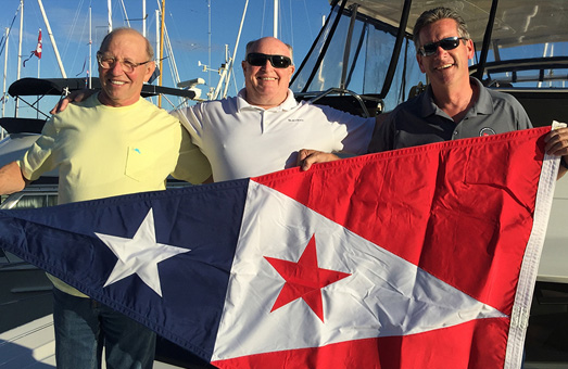 Members of the San Francisco Yacht Club holding a flag