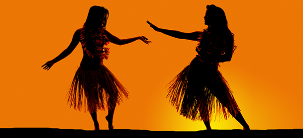 two Hawaiian dancers dancing during sunset