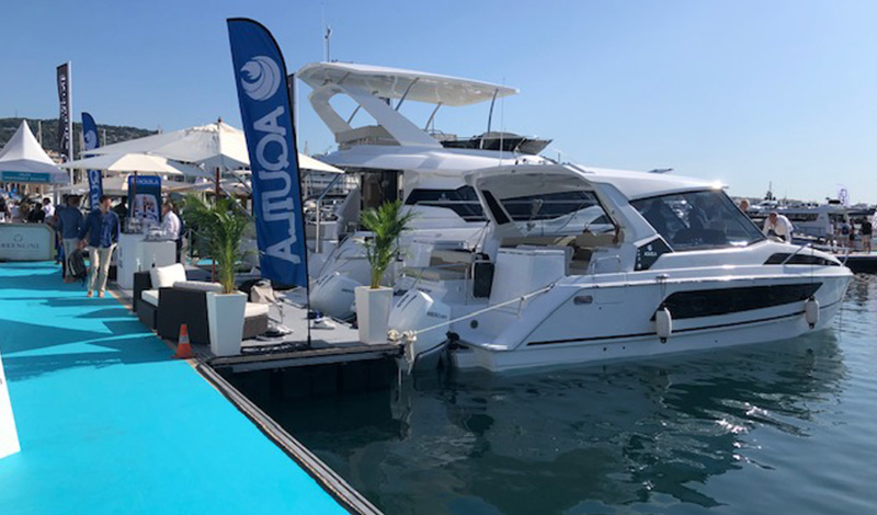 aquila power catamarans docked at the cannes yachting festival with an aquila banner waving