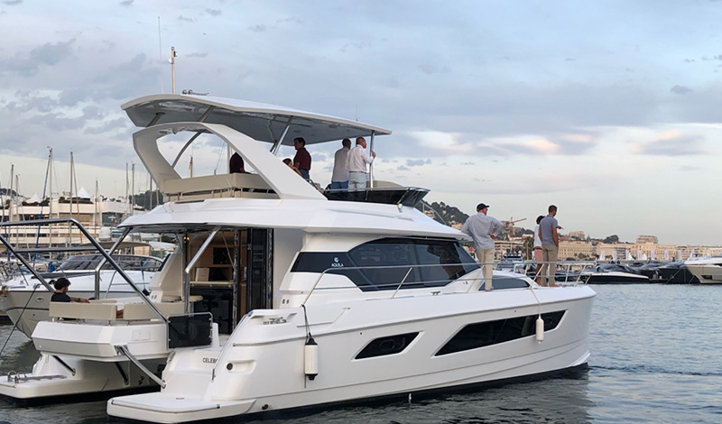 an aquila power catamaran anchored in a marina with several people aboard