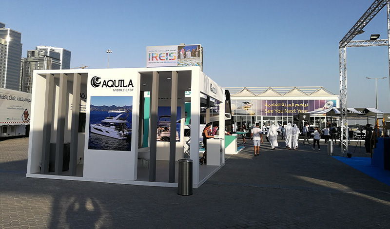 a white aquila booth at the abu dhabi international boat show
