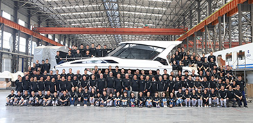 team of factory workers sitting in front of an aquila catamaran