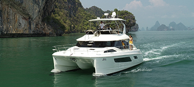 Aquila 70 Luxury Power Catamaran on the water with mountains on the background