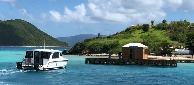 An Aquila 36 Excursion cruising towards a fuel station in the British Virgin Islands, surrounded by blue water