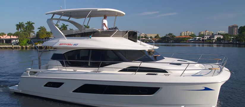 A man in in a white shirt standing on the flybridge of the Aquila 44