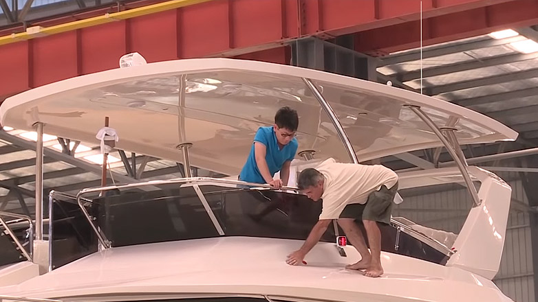 Two people working on Aquila boat in factory