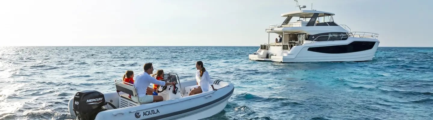 Family riding on a rib next to their 50 yacht